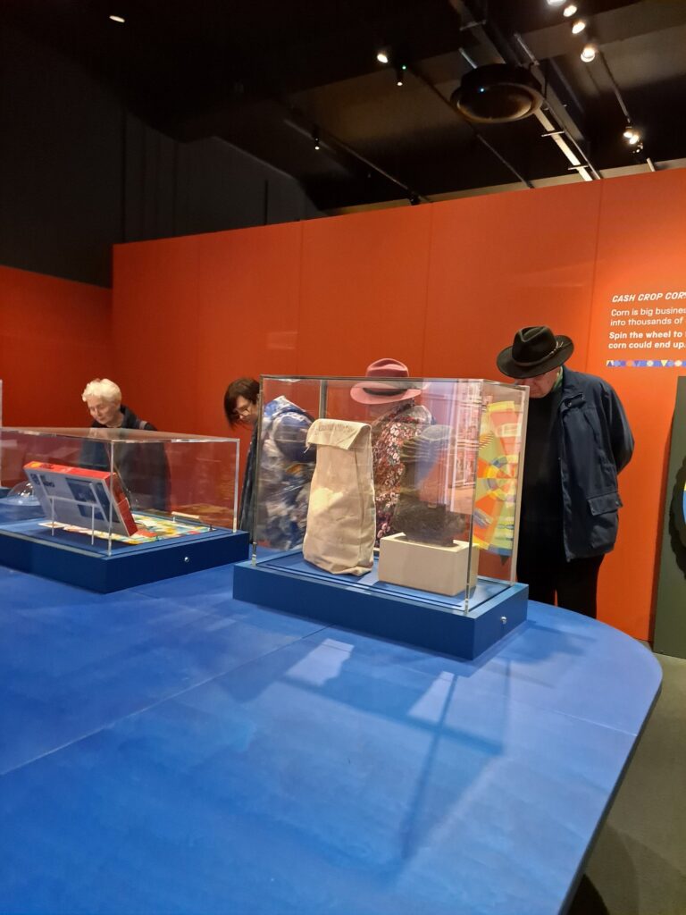 three women and a man study museum exhibit